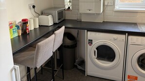 A compact kitchen with a washing machine, a microwave, and a sink.
