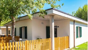 Ein eingeschossiges Gebäude mit überdachter Veranda, Holzzaun und der Hausnummer 2549.