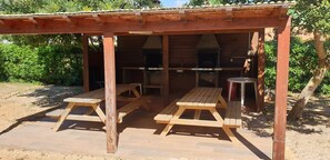 A wooden pavilion with picnic tables and a barbecue area. - 15mins walk to beach! Cozy apartment with communal pool and BBQ area! (Alvor)