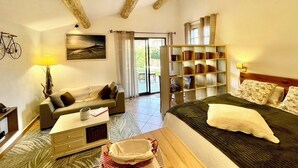 A bedroom with a bed, a sofa, a bookshelf, a desk, and a window. - La belle histoire du gîte Ventoux (Bédoin)