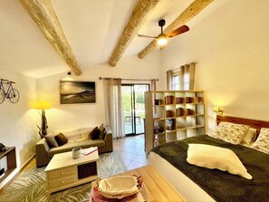 A bedroom with a bed, a sofa, a bookshelf, a desk, and a window. - La belle histoire du gîte Ventoux (Bédoin)