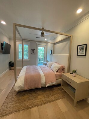 A bedroom with a bed, bedside table, and a TV mounted on the wall. - Beautiful house in Islamorada (Islamorada)