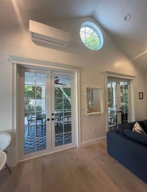 A room with a ceiling fan, a large window with a view, and a sliding glass door leading to an outdoor area. - Beautiful house in Islamorada (Islamorada)