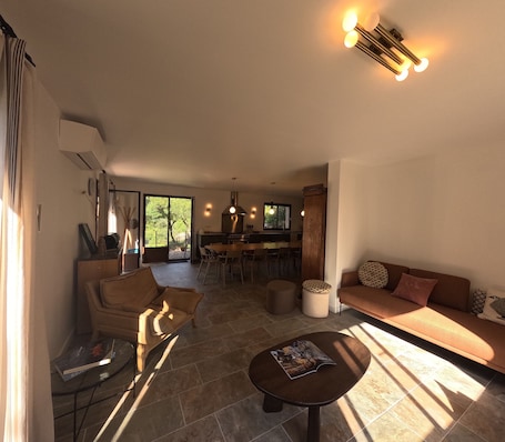 A modern living room with a sofa, coffee table, and dining area.. Guesthouse at the Farm "U Bene Stà - Rinicciu" with Mountain View, Wi-Fi, and Air Conditioning