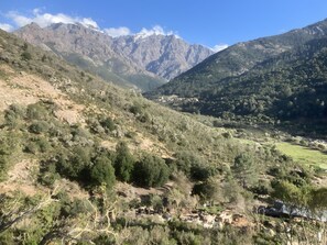 Vuoristoinen maisema, jossa on laakso, puita ja pieni asutuskeskus.