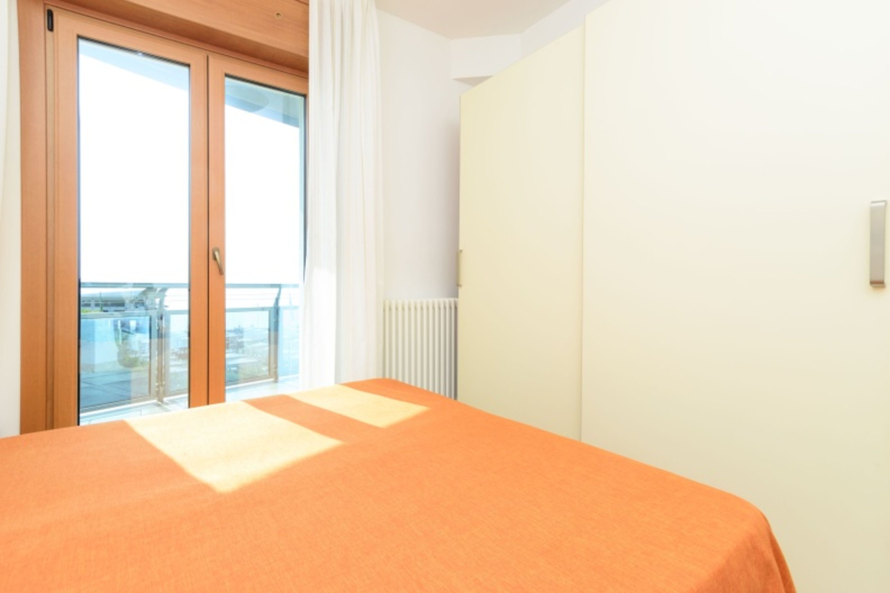 Une pièce avec un lit, une fenêtre et un radiateur.