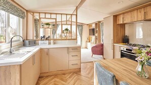 A compact kitchen with a sink, toaster, and wooden cabinets. - Host & Stay | Molly's Place (Morpeth)