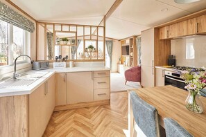 Eine kleine Küche mit Spüle, Toaster und Holzausstattung.