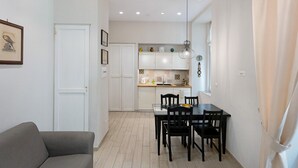 Un espace de vie compact comprenant un coin repas, une kitchenette et un canapé.