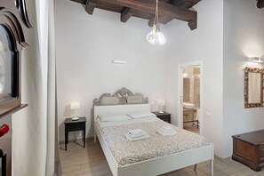 Ein Schlafzimmer mit Bett, Nachttischen, einem Spiegel und einem Kleiderschrank.