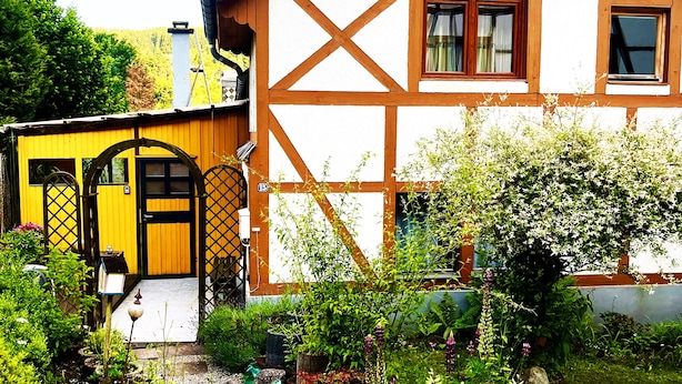 A traditional half-timbered house with a garden pathway leading to the entrance. - Viktorias Villa (Schleiden)