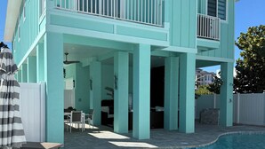 A two-story house with a swimming pool, outdoor furniture, and a covered patio area. - Ft. Myers Beach across street to Beach Golf Cart (Fort Meyers Beach)