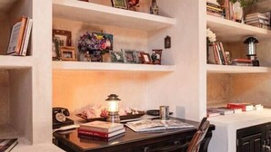 Ein Arbeitszimmer mit Schreibtisch, Stuhl und Regalen mit Büchern und Dekoration.