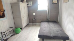 A bedroom with a bed, a wardrobe, a lamp, and a picture frame on the wall. - House with swimming pool in the heart of the seaside resort of Ronce /La Tremblade (La Tremblade)