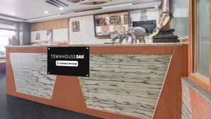 Un comptoir d’accueil au design inspiré du marbre, un ventilateur de plafond et des statues religieuses.