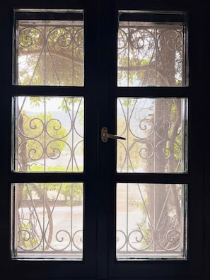 A door with four windows, each featuring decorative metal grilles. - Large Villa with Pool and Private Tennis Court near Ormos Korthiou (Ormos Korthiou)