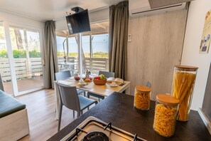 Ett modernt kök med matplats, TV och utsikt över omgivningarna.