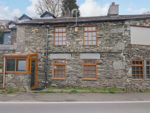 A stone building with three windows and a small porch. - Wilders Wood (Windermere)