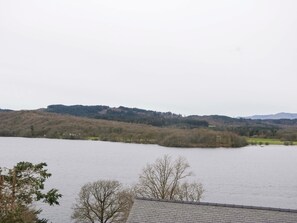 A lake with a forested hill in the background. - Wilders Wood (Windermere)