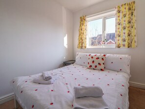 A bedroom with a bed, pillows, and a window with curtains. - 10 Church Walks (Chester)