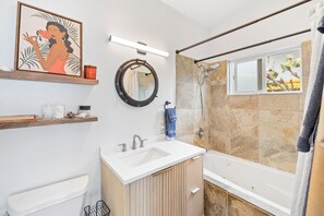 Une salle de bain moderne avec un lavabo, un miroir et une douche.