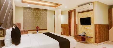 A hotel room with a bed, a TV, an air conditioner, and a wooden ceiling.
