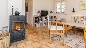 Una sala de estar acogedora con chimenea, televisor y comedor.