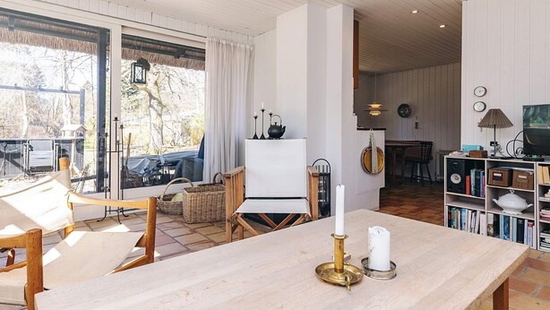 Amplia sala de estar con una mesa grande, chimenea y vistas al exterior.