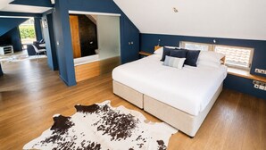 Une chambre avec un grand lit, un tapis en peau de vache et une vue sur l’extérieur.
