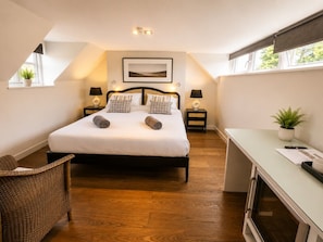 A bedroom with a bed, two bedside tables, a desk, a chair, and a window. - Stylish and Cosy Retreat CoCoes TWO (Swaffham)