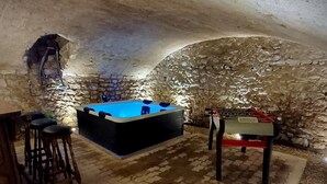A stone-walled room with a pool table, bar stools, and a billiards table. - Gite "La Greniette (Châteauneuf-sur-Loire)