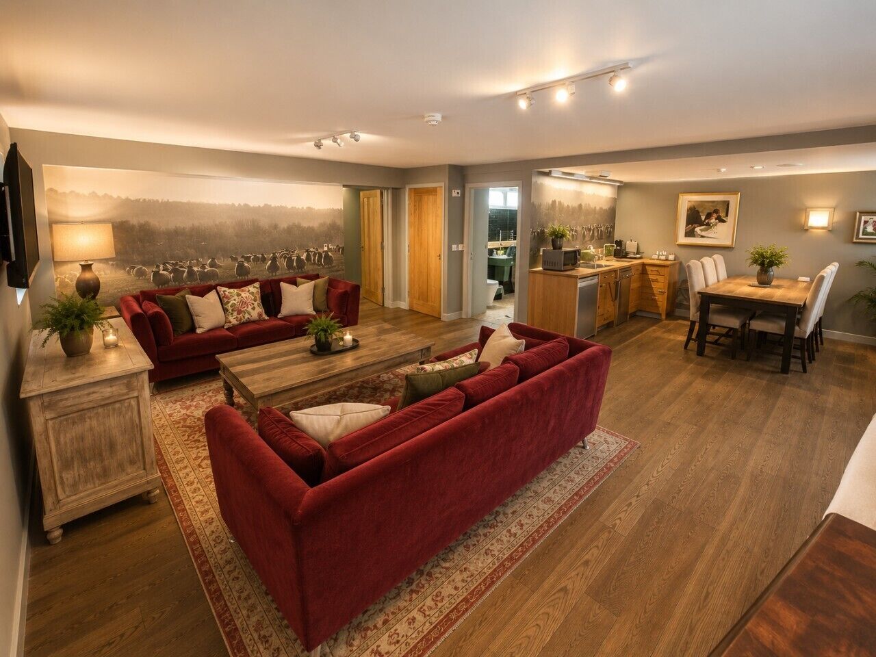 A spacious living room with a red sofa set, a wooden coffee table, and a dining area with a table and chairs.