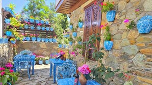 A stone building with blue-painted furniture and potted plants. - Sirincem Plus (Selcuk)