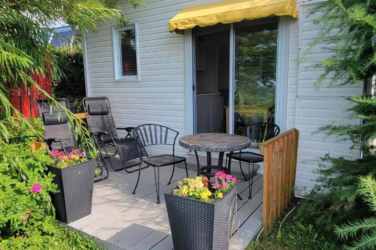 Un patio con mobiliario exterior, una puerta corrediza de vidrio y un toldo amarillo.