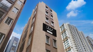 Un edificio alto con un letrero que indica que es un conjunto de departamentos con servicios de empresa.