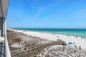 A beach view with a wooden walkway leading to the shore, sandy beach, and ocean. - Vibrant 3BR gulf front condo with beach access (Okaloosa Island)