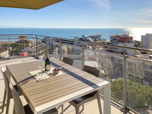 Ein Balkon mit Tisch, einer Champagnerflasche und einer Schale Pralinen.