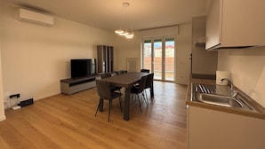 Eine moderne Wohnung mit Essbereich, Küche und Fernseher.