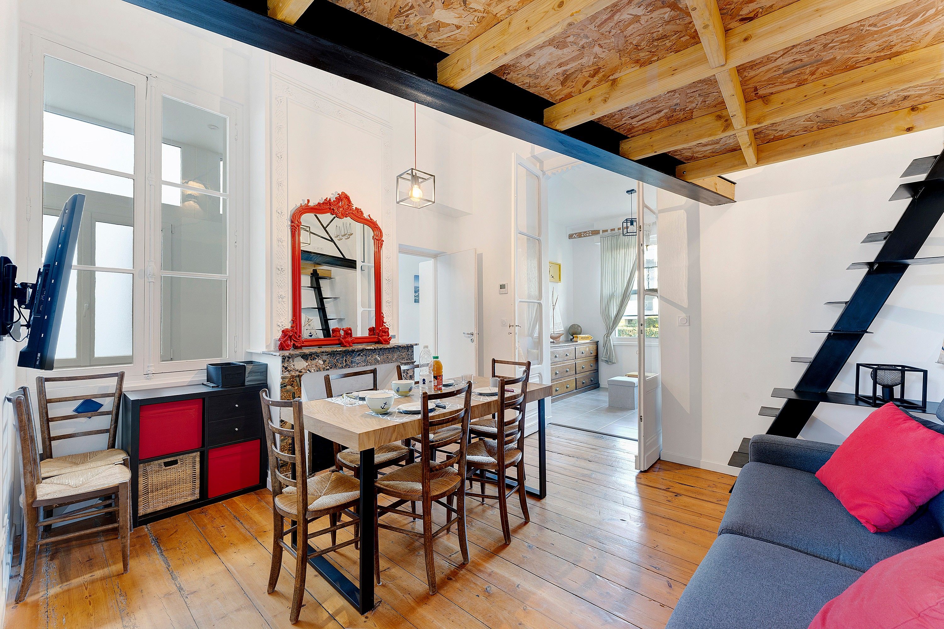 A spacious room with a dining area, a staircase, and a view of the outdoors.