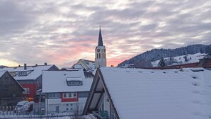 Un village enneigé avec une église et des immeubles d’habitation.