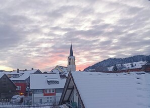 A snow-covered village with a church and residential buildings. - Allgäu Vibes-OberstaufenPLUS, train station access, view, protected balcony (Oberstaufen)