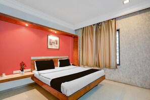 Un dormitorio con una cama de madera, una mesita de noche, un jarrón con flores, una ventana con cortinas y una pared roja.