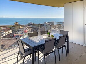 Ein Balkon mit Tisch für Zwei, einer Champagnerflasche und einer Schale Weintrauben.