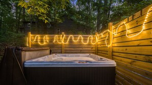 A hot tub with a wooden deck and a string of lights. - Mountain Retreat: Year-Round Getaway, Pup Friendly (Wintergreen Resort)