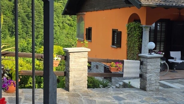 A stone patio with a view of a mountain and a building with a yellow facade.