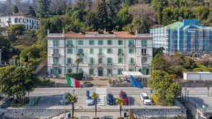 A hotel with a central courtyard, multiple balconies, and a view of the surrounding hills. - Miraluna – Lake Como View Balcony (Griante)