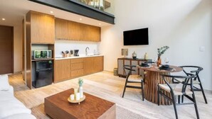 Eine moderne Küche mit Holzausstattung, einem integrierten Kühlschrank und einem Essbereich mit rundem Tisch und Stühlen.