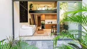Ein modernes Interieur mit Sofa, Essbereich, Küche und Treppe.