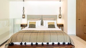 Ein Schlafzimmer mit einem großen Bett, zwei Nachttischen und Pendelleuchten.