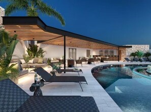 A modern outdoor pool area with lounge chairs, a covered seating area, and a stone wall. - Paramar Black 2BR Apt / Two Pools-Sauna-Concierg (Tulum)